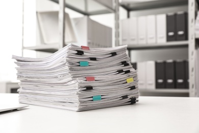 Stack of documents with paper clips on office desk. Space for text