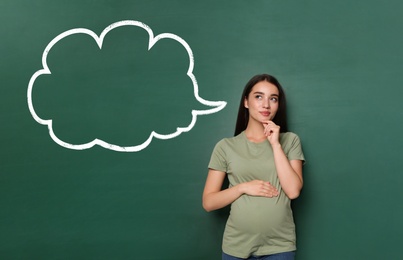 Image of Emotional pregnant woman choosing name for her child. Future mother near green chalkboard with empty thought cloud