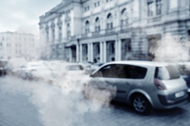 Image of Environmental pollution. Air contaminated with fumes in city. Cars surrounded by exhaust on road, blurred view