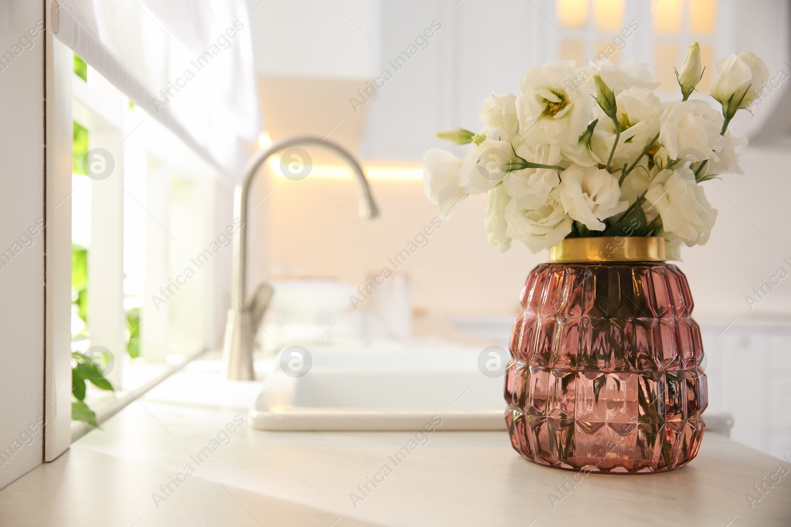 Photo of Bouquet of beautiful flowers on countertop in kitchen, space for text. Interior design