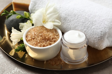 Photo of Spa composition with sea salt on golden tray, closeup