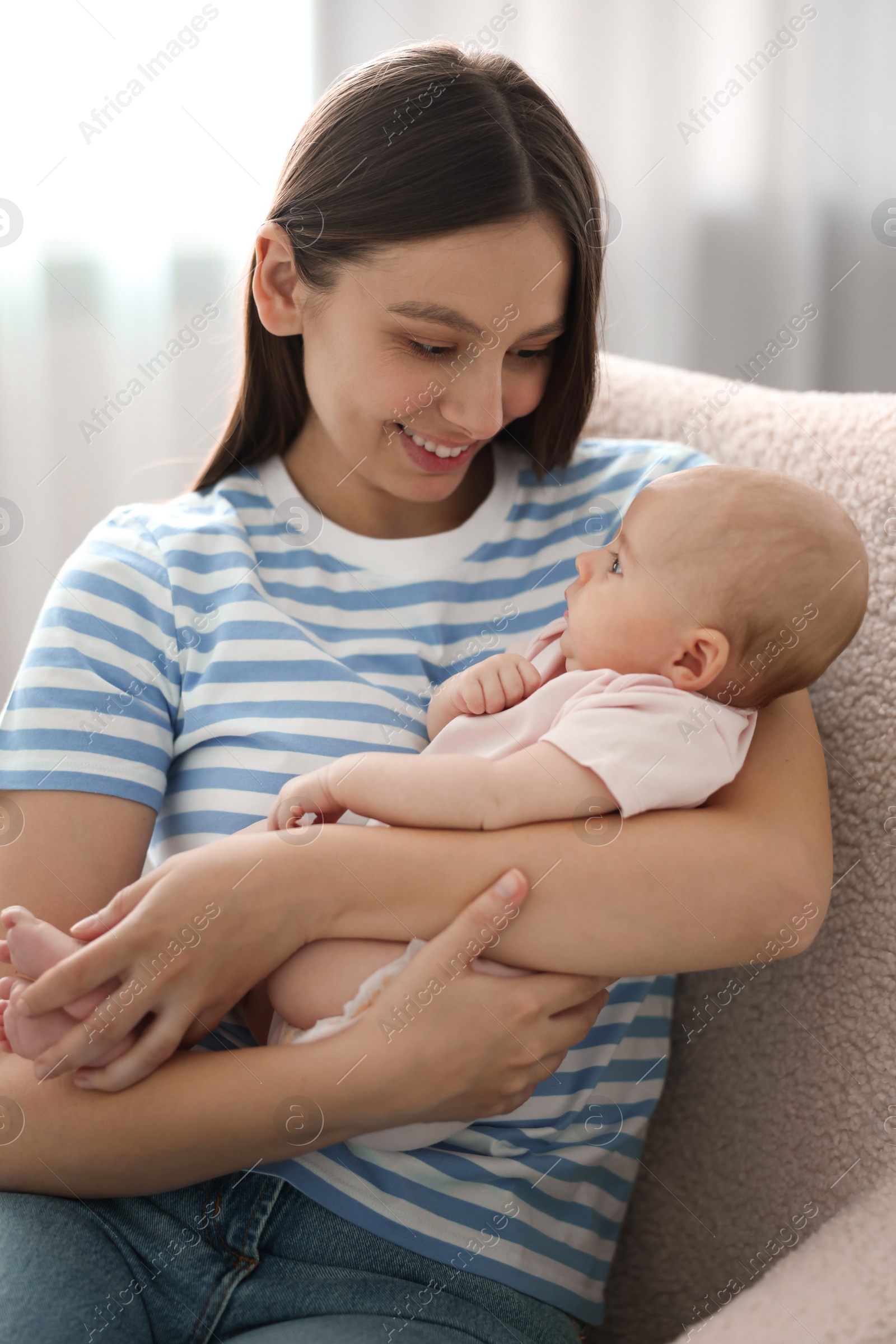 Photo of Mother with her cute baby in armchair at home