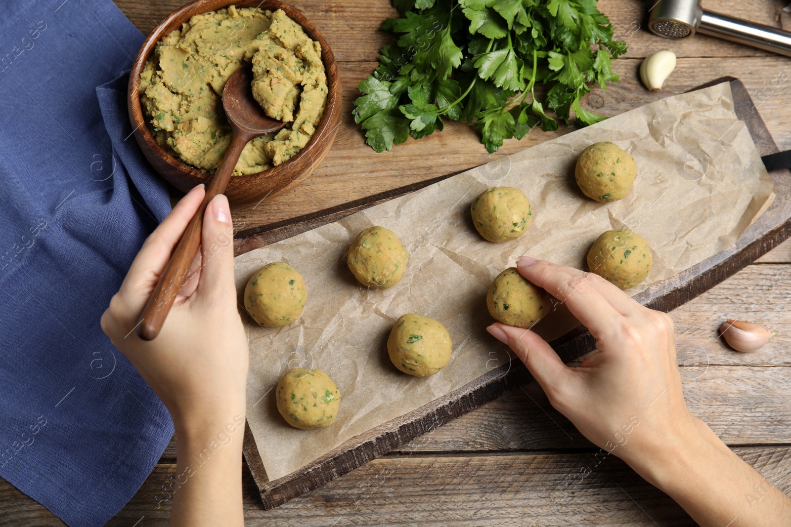 Photo of Woman making falafel balls at wooden table, top view