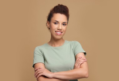 Photo of Portrait of beautiful young woman on light brown background