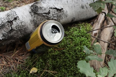 Photo of Used aluminum can on ground outdoors, closeup. Recycling problem