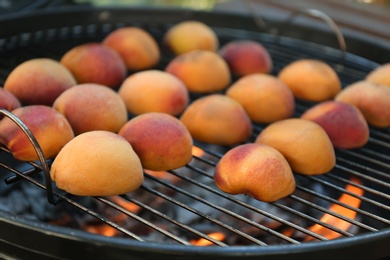 Photo of Modern grill with tasty juicy peaches, closeup