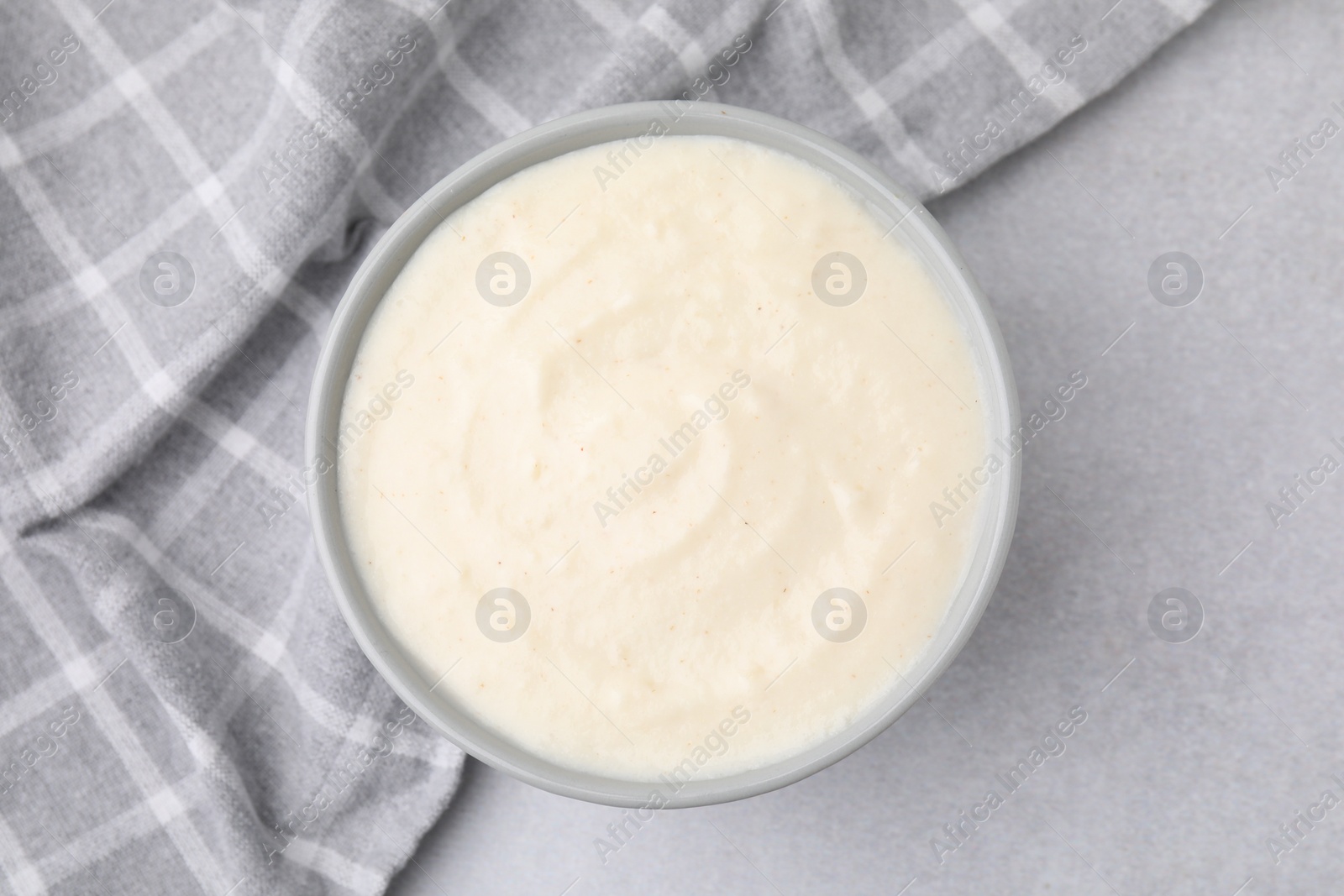 Photo of Delicious semolina pudding in bowl on light grey table, top view