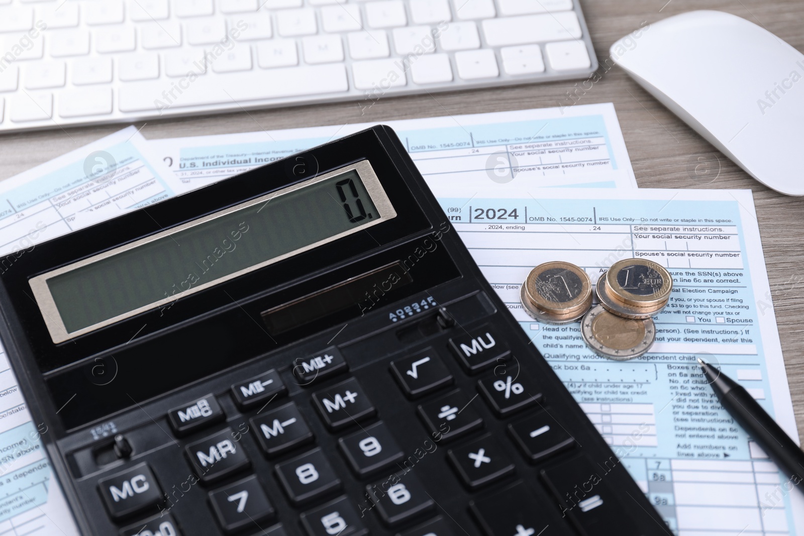 Photo of Tax accounting. Calculator, documents, coins, keyboard and pen on wooden table, closeup