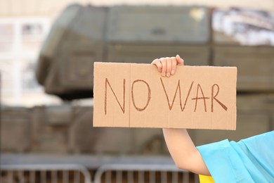 Photo of Woman holding poster with words No War outdoors, closeup