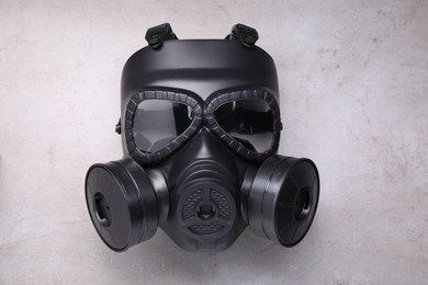 One gas mask on grey textured background, top view