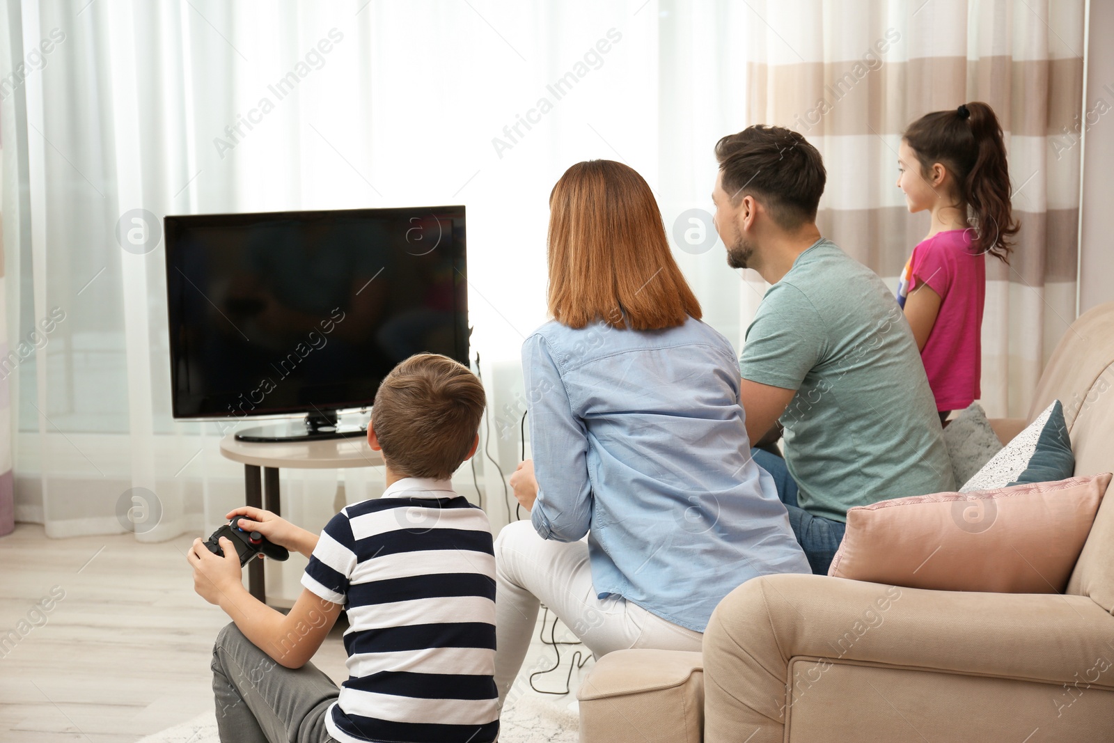 Photo of Happy family playing video games in living room