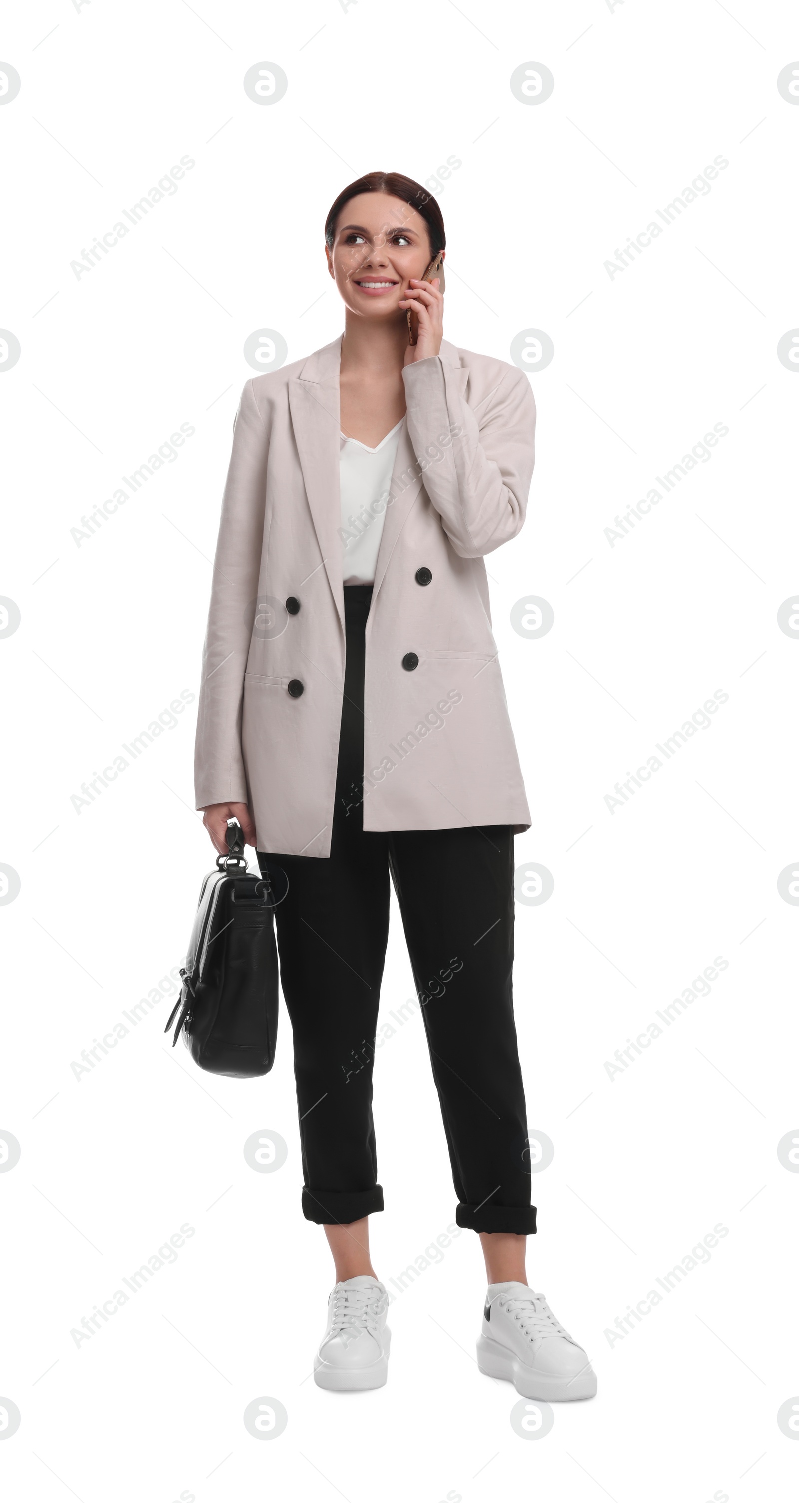 Photo of Beautiful businesswoman in suit with briefcase talking on smartphone against white background