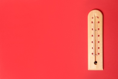 Weather thermometer on red background, top view. Space for text