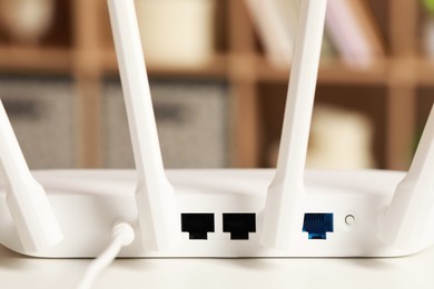 Photo of New Wi-Fi router on white table indoors, back view
