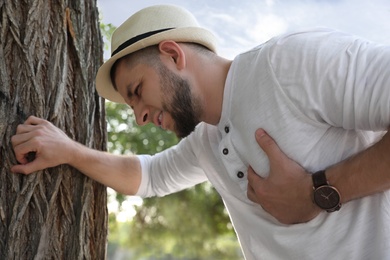 Photo of Man having heart attack near tree in park