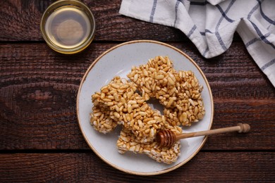 Plate with puffed rice bars (kozinaki) on wooden table, flat lay