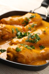 Photo of Tasty chicken curry with parsley on wooden table, closeup