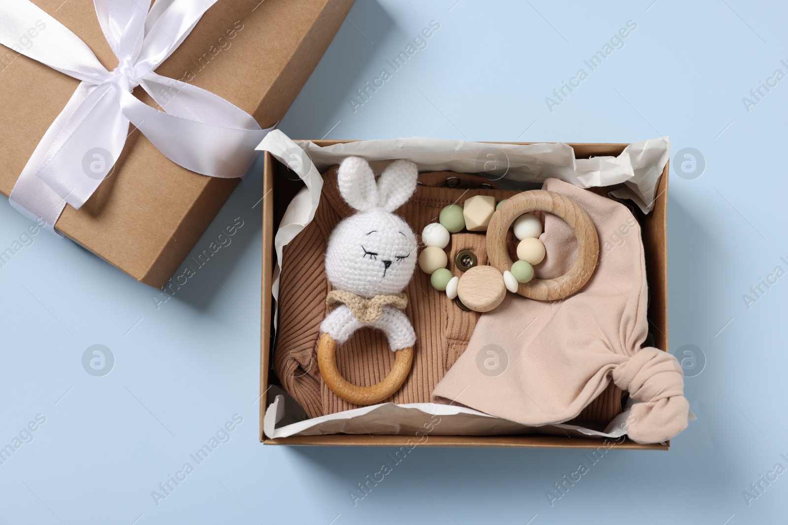 Photo of Different baby accessories in box on light blue background, flat lay