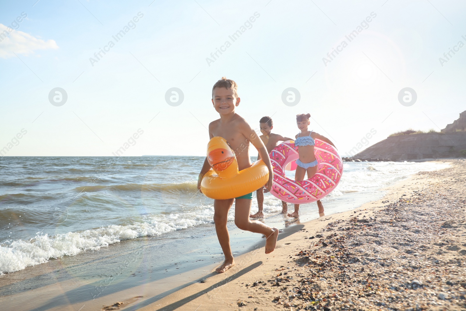 Photo of Cute children enjoying sunny day at beach. Summer camp