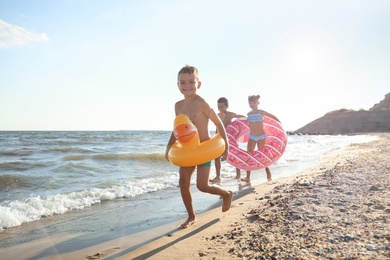 Cute children enjoying sunny day at beach. Summer camp