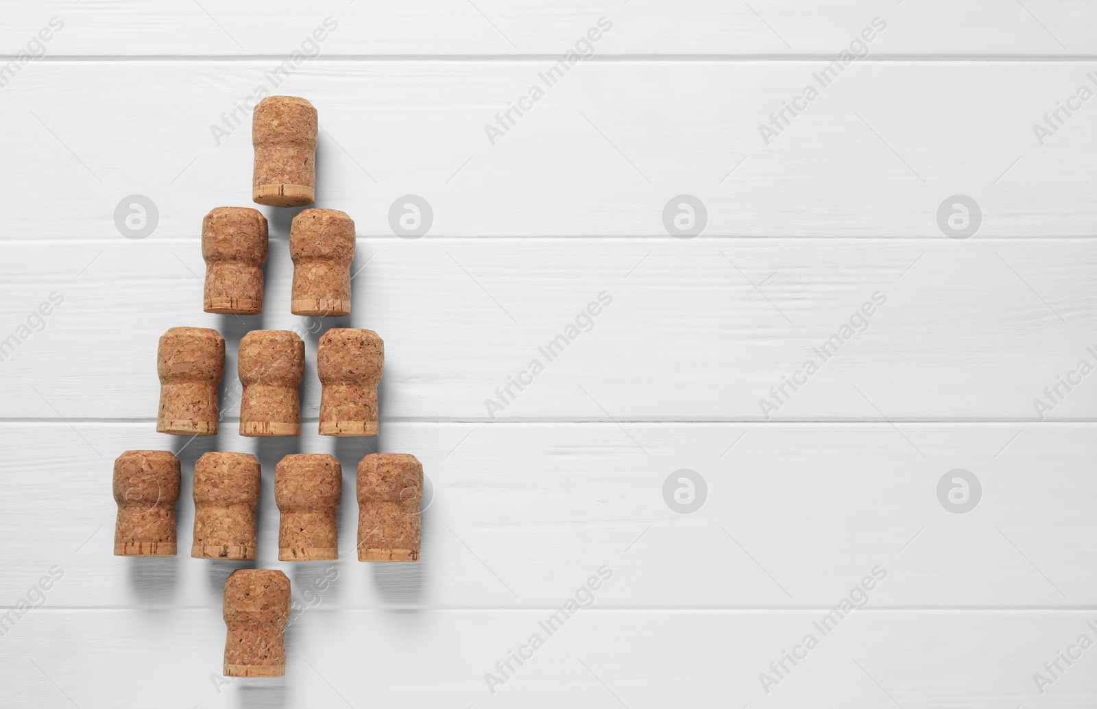 Photo of Christmas tree made of wine corks on white wooden table, top view. Space for text