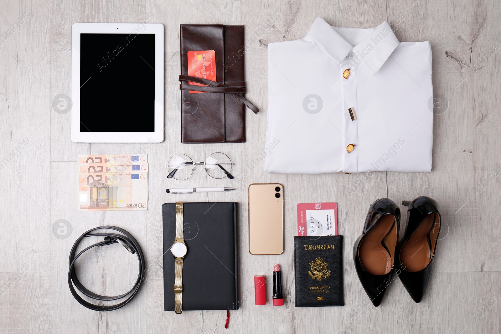 Photo of Business trip stuff on light wooden surface, flat lay