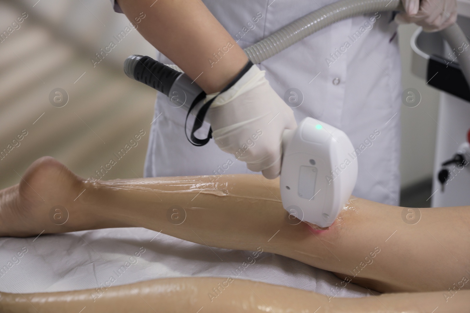 Photo of Woman undergoing laser epilation procedure in beauty salon, closeup