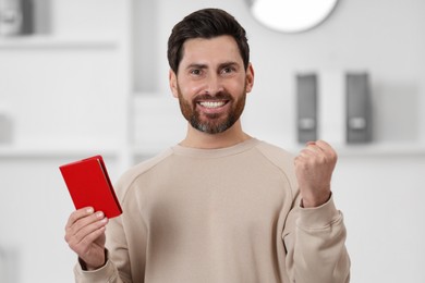 Photo of Immigration. Portrait of happy man with passport indoors