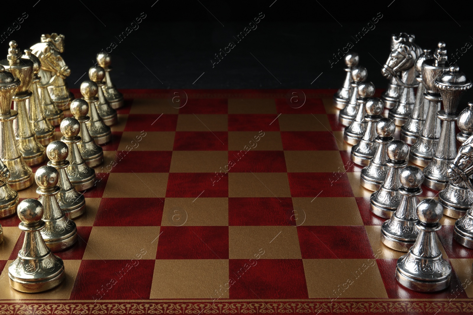 Photo of Chessboard with game pieces on black background