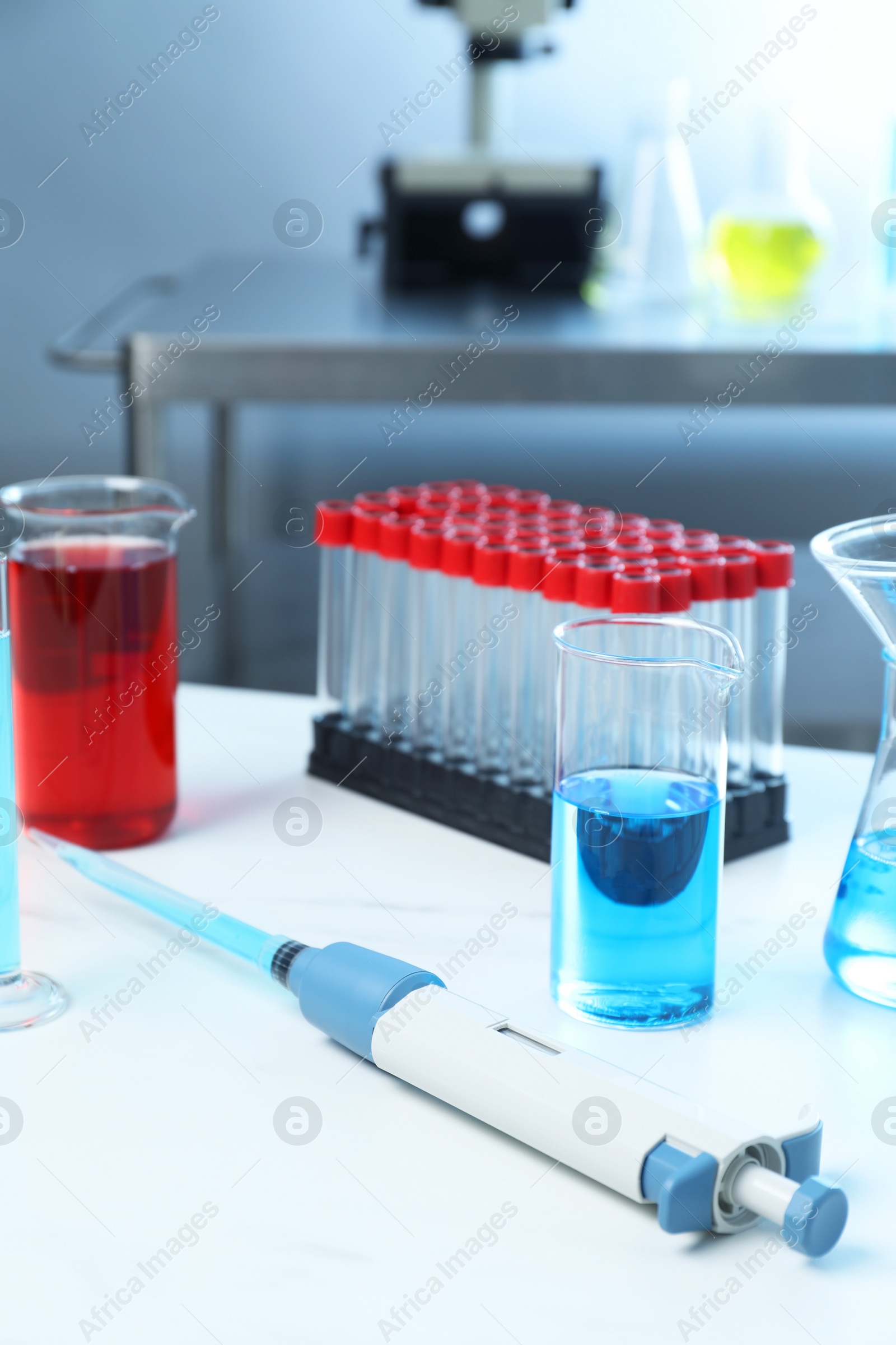 Photo of Laboratory analysis. Micropipette and different glassware on white marble table