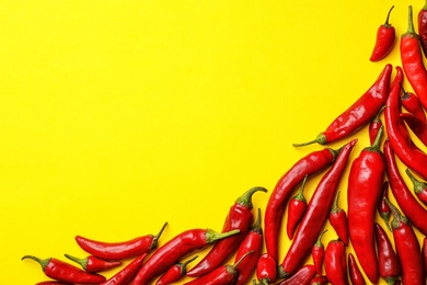 Photo of Flat lay composition with fresh chili peppers and space for text on color background