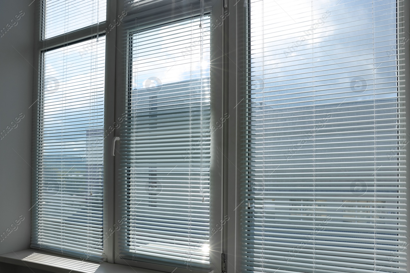 Photo of Stylish window with horizontal blinds in room