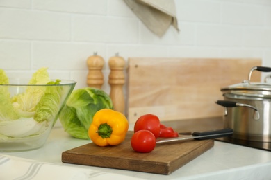 Photo of Fresh vegetables on white countertop in modern kitchen