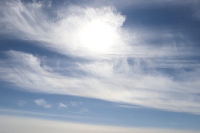 Bright sun and fluffy white clouds in blue sky