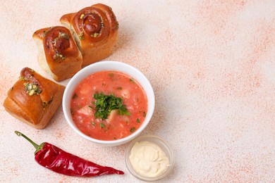 Photo of Delicious borsch served with pampushky on color textured table, space for text. Traditional Ukrainian cuisine