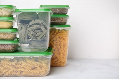 Photo of Plastic containers filled with food products on white table. Space for text