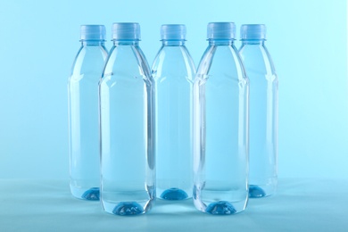 Photo of Collection of plastic bottles with water on color background