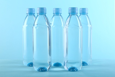 Collection of plastic bottles with water on color background