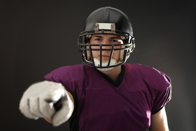 American football player wearing uniform on dark background