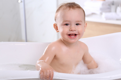 Cute little baby in bathtub at home