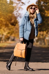 Photo of Young woman with stylish backpack on autumn day