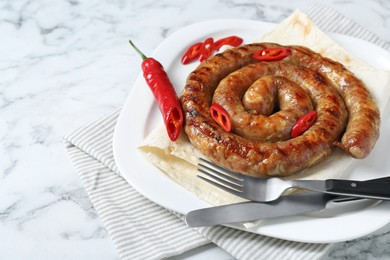 Photo of Delicious homemade sausage with chili pepper and lavash served on white marble table