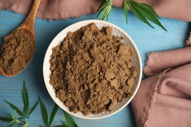 Hemp protein powder and fresh leaves on light blue wooden table, flat lay