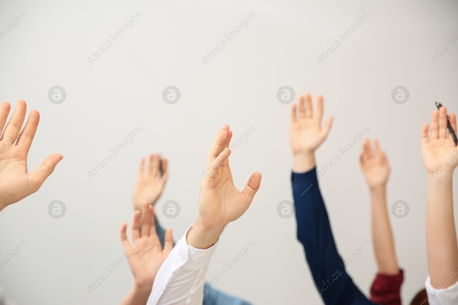 Photo of People raising hands to ask questions at business training on white background, closeup