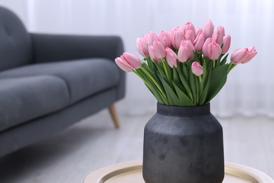 Photo of Bouquet of beautiful pink tulips in vase on table indoors, space for text