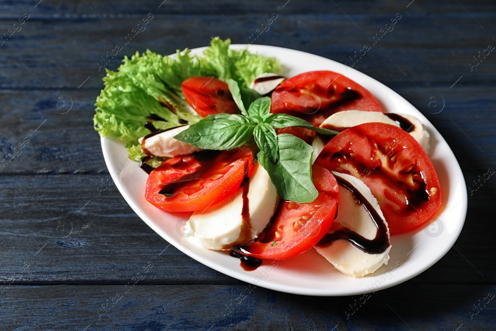 Photo of Plate with delicious fresh salad on table