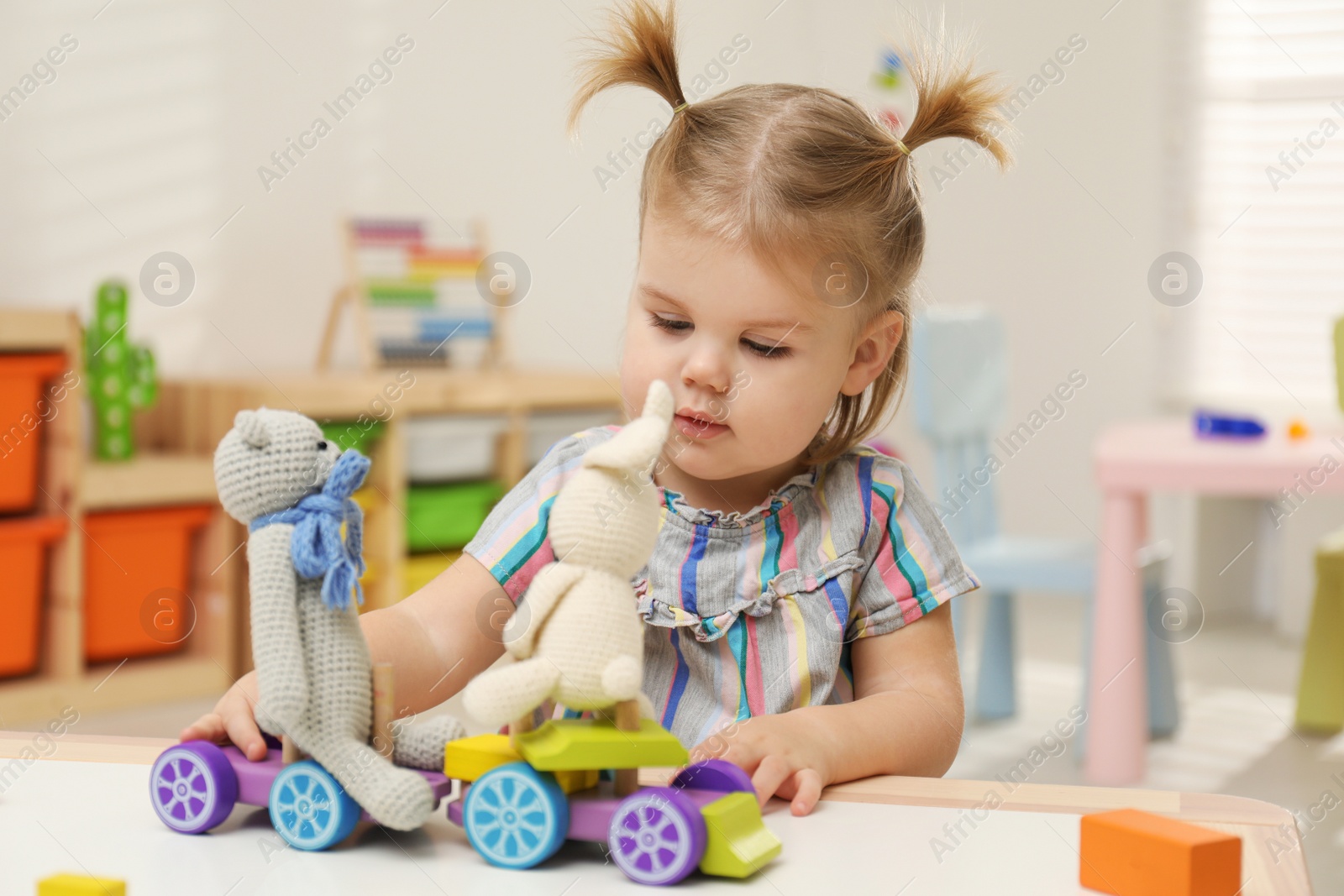 Photo of Little girl playing with toys at table