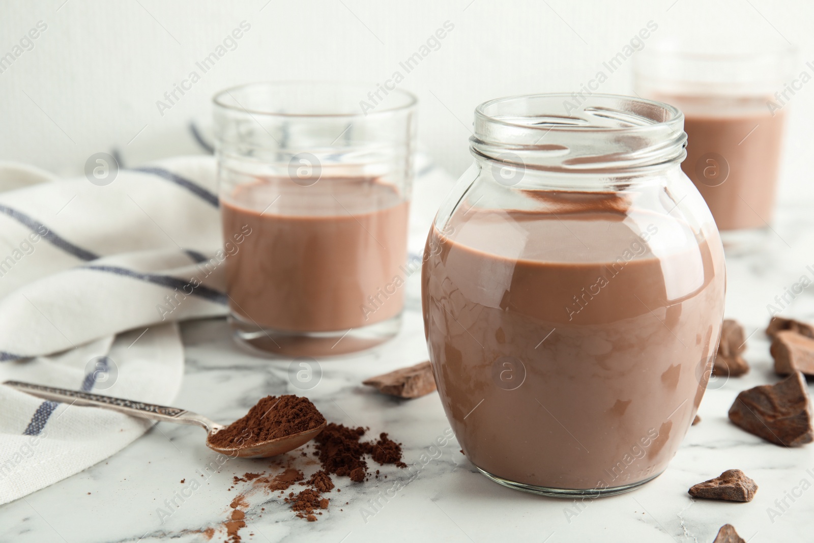 Photo of Glassware with tasty chocolate milk on marble table. Dairy drink