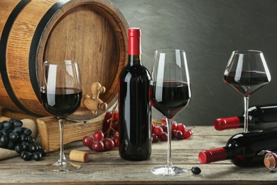 Photo of Winemaking. Composition with tasty wine and barrel on wooden table against gray background