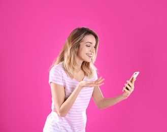 Photo of Woman using mobile phone for video chat on color background